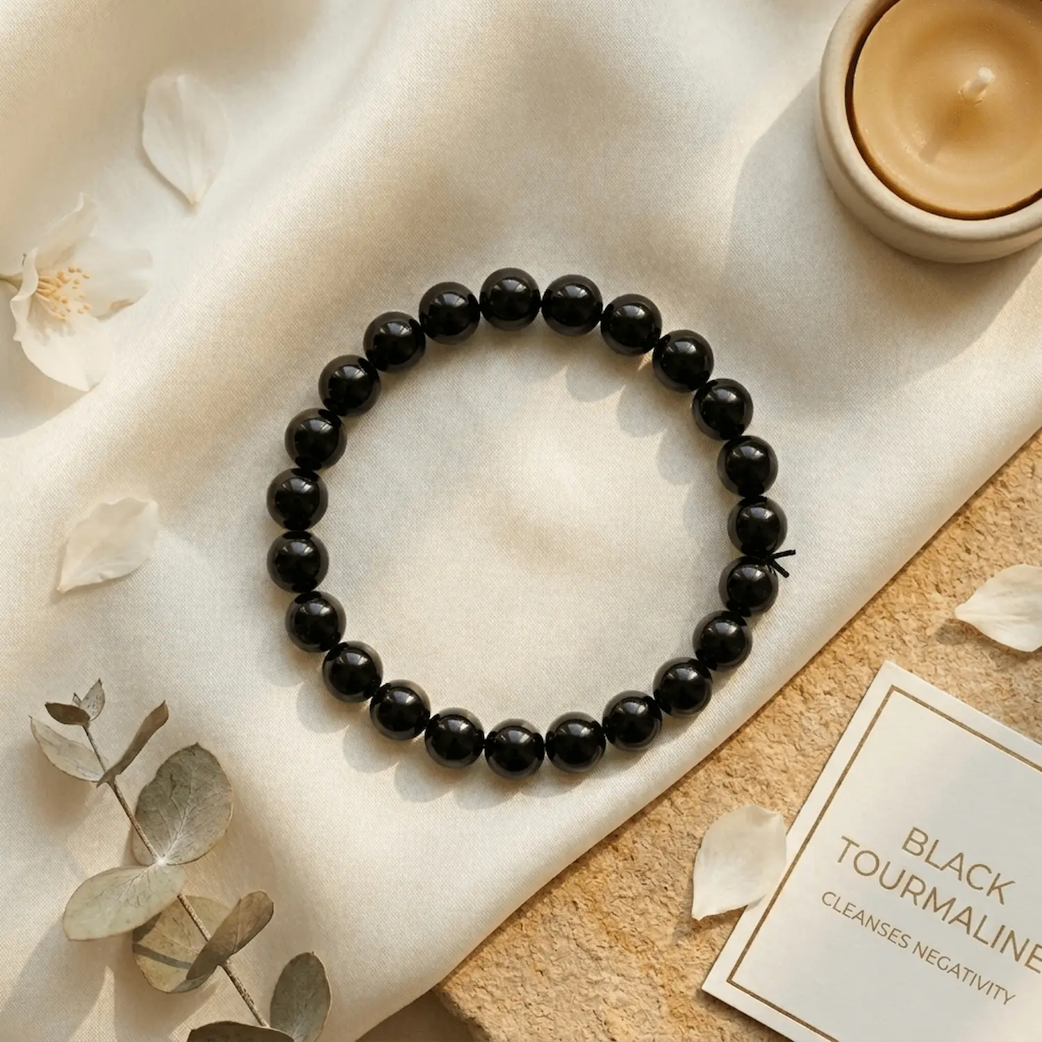 Black tourmaline bracelet styled with minimal decor and cleansing energy theme