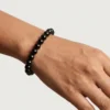 Close-up of black tourmaline bracelet on wrist highlighting bead size and shine