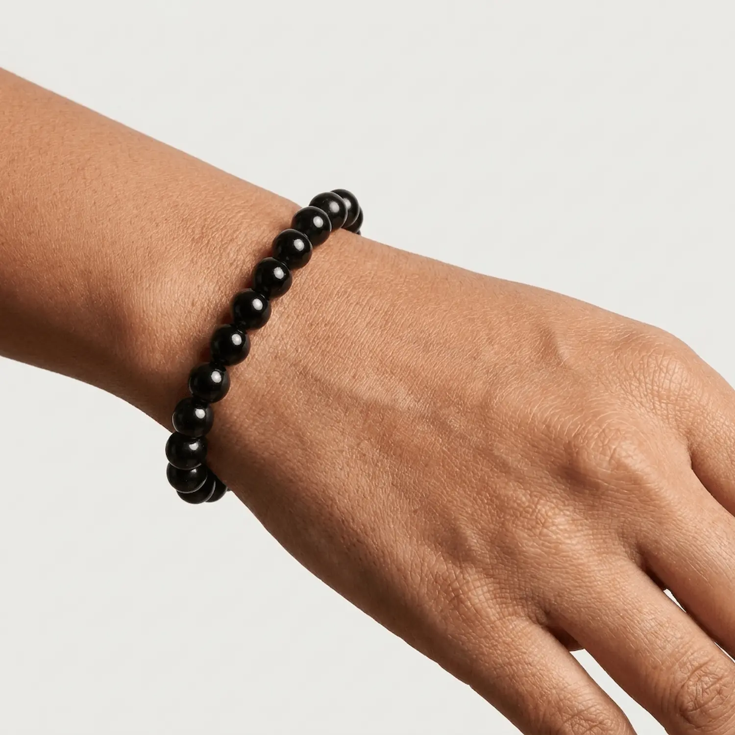 Close-up of black tourmaline bracelet on wrist highlighting bead size and shine