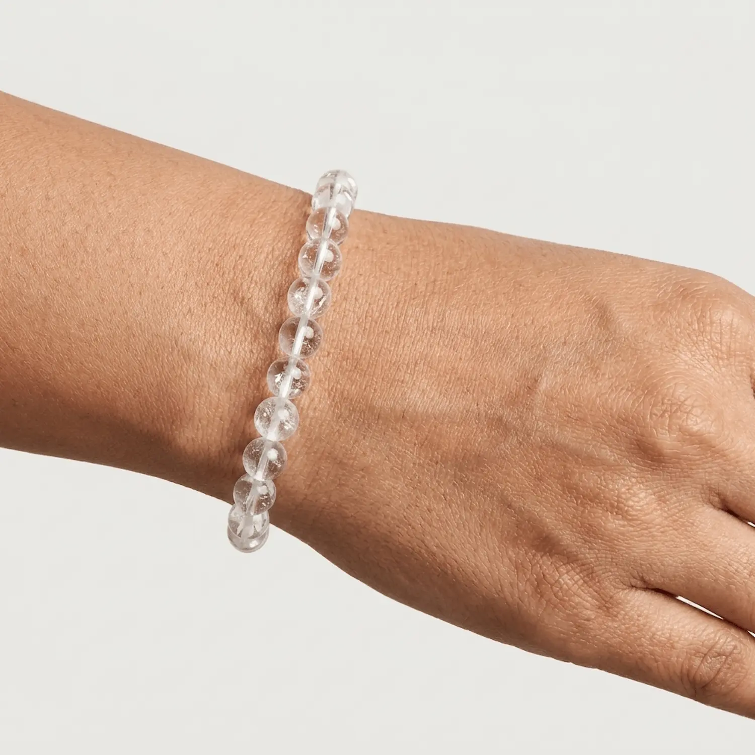 Woman wearing clear quartz bracelet 8mm during meditation and mindfulness