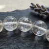 Macro close-up of clear quartz bracelet 8mm showing natural inclusions and internal fractures