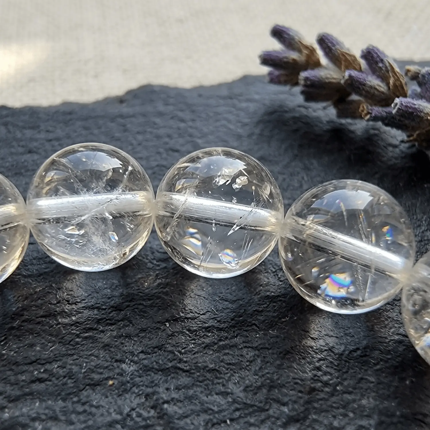 Macro close-up of clear quartz bracelet 8mm showing natural inclusions and internal fractures