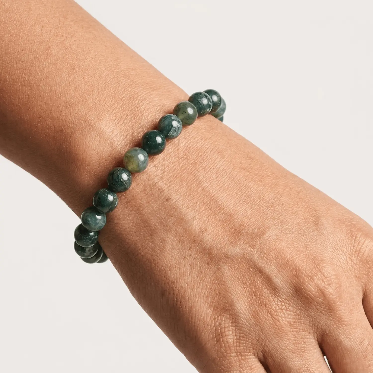 Close-up of polished 8mm Moss Agate crystal bracelet
