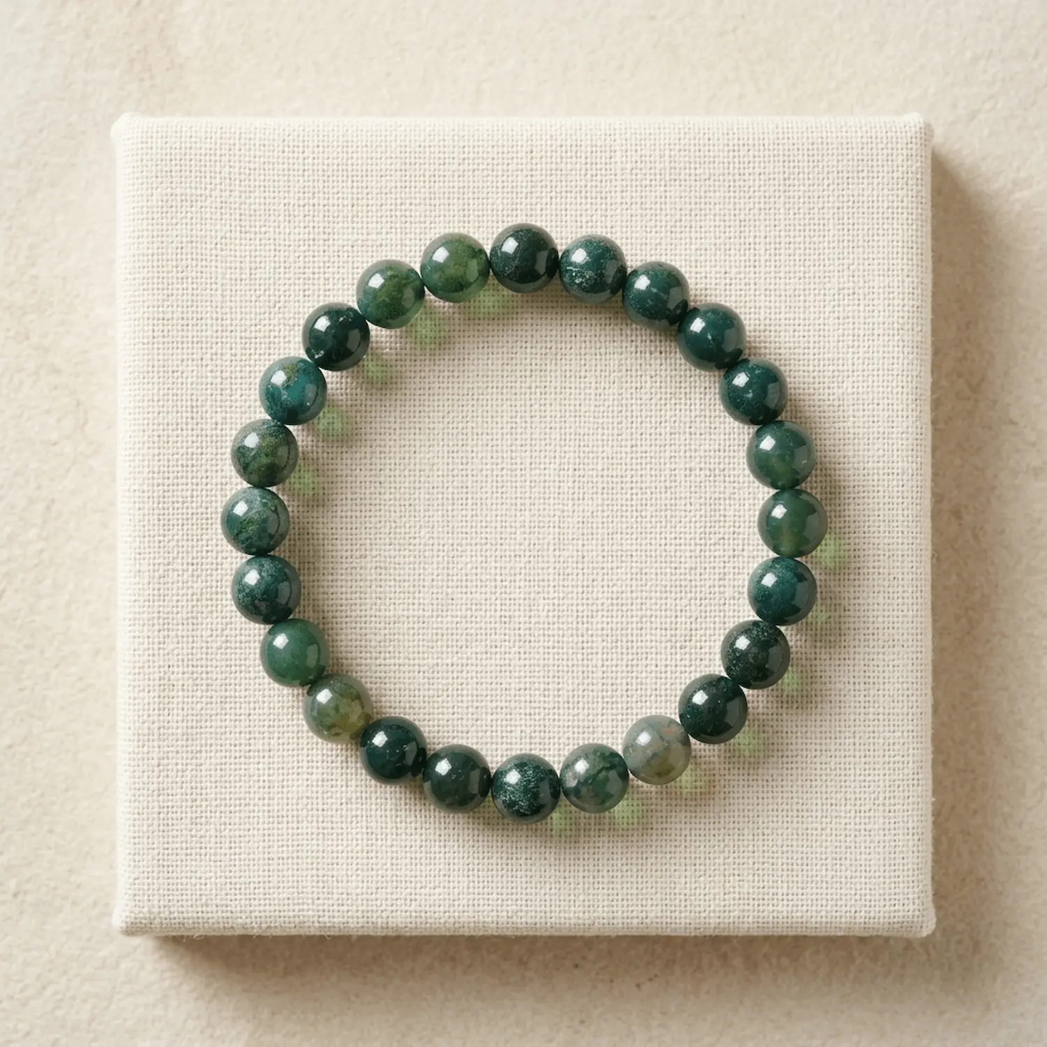 Moss Agate 8mm beaded bracelet displayed on a fabric background