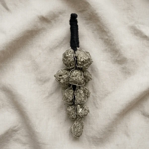 Pyrite crystal hanger displayed on textured fabric with natural pyrite stones