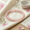 Rose Quartz crystal bracelet styled with pink petals and soft neutral decor for elegant feminine crystal photography