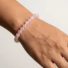 Rose Quartz crystal bracelet with soft pink 8mm gemstone beads worn on wrist in minimal studio lighting