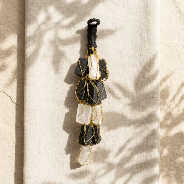 Selenite and Black Tourmaline crystal hanger displayed on textured fabric