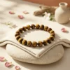 Tiger’s Eye crystal bracelet styled with soft neutral decor, petals and natural elements for an elegant aesthetic display