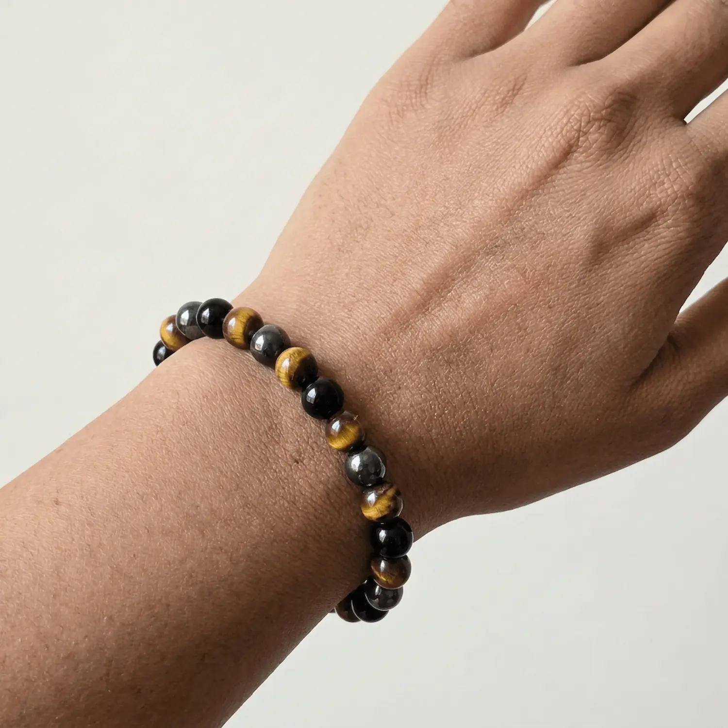 Close up of Triple Protection Combination crystal bracelet with Tiger Eye, Hematite and Black Obsidian beads worn on wrist