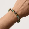 Close up of Wealth Combination crystal bracelet with Green Aventurine Tiger Eye and Pyrite beads worn on wrist