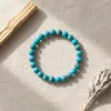 African turquoise crystal bracelet with round blue-green beads on neutral background
