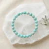 Amazonite crystal bracelet 8mm with round blue-green beads on white selenite background