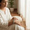 Woman wearing an 8mm amazonite crystal bracelet in a calm indoor setting