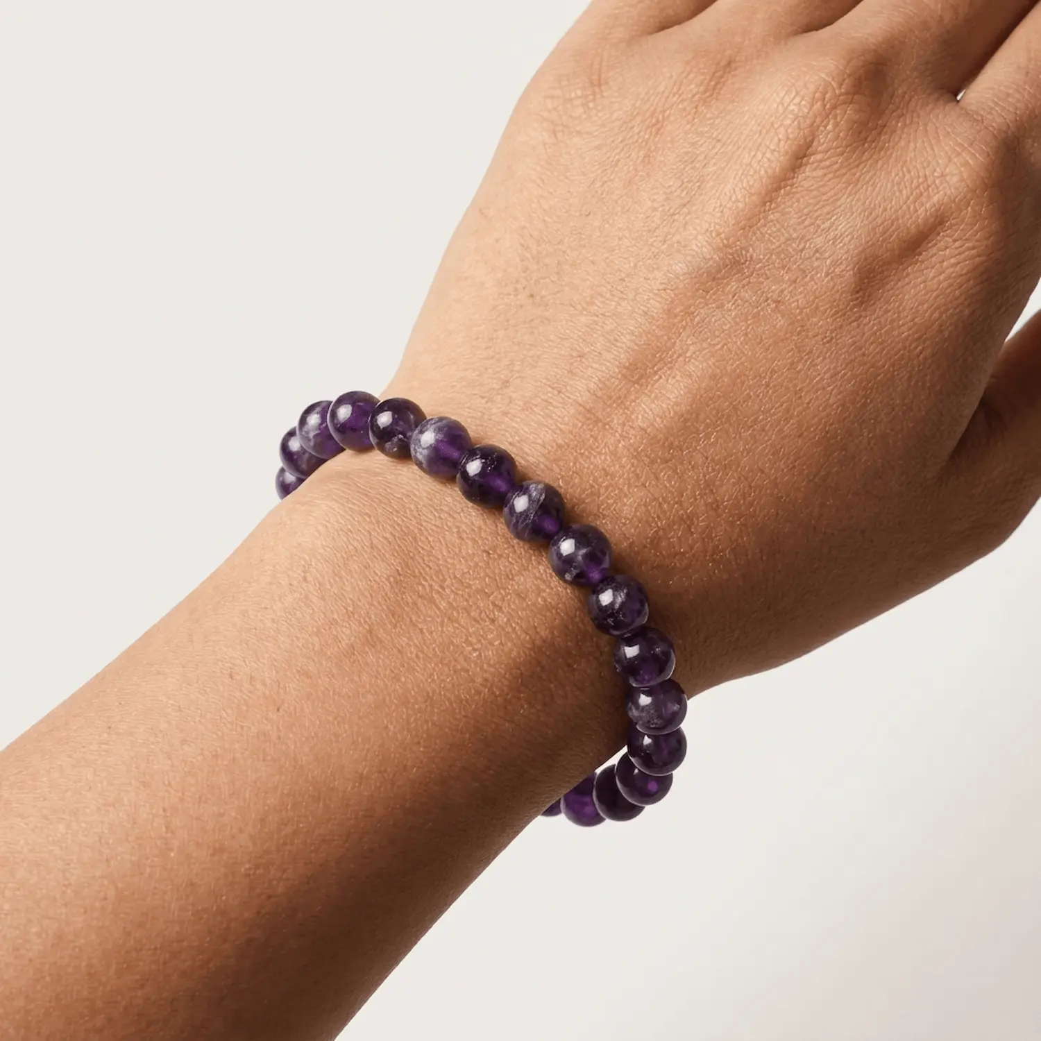 Close-up of amethyst 8mm crystal bracelet on wrist showing bead color and shine