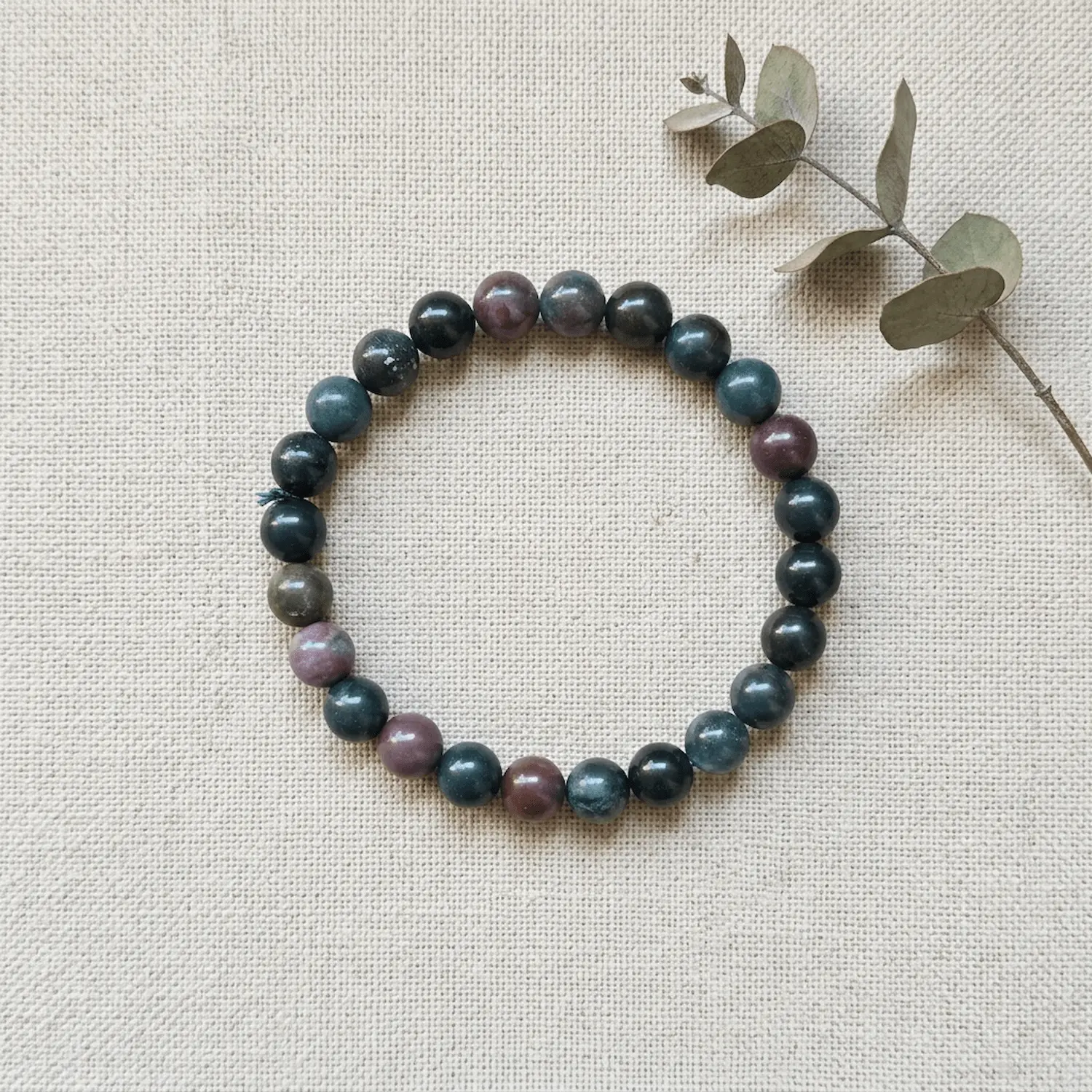8mm Bloodstone crystal bracelet on neutral fabric background showing natural bead variation