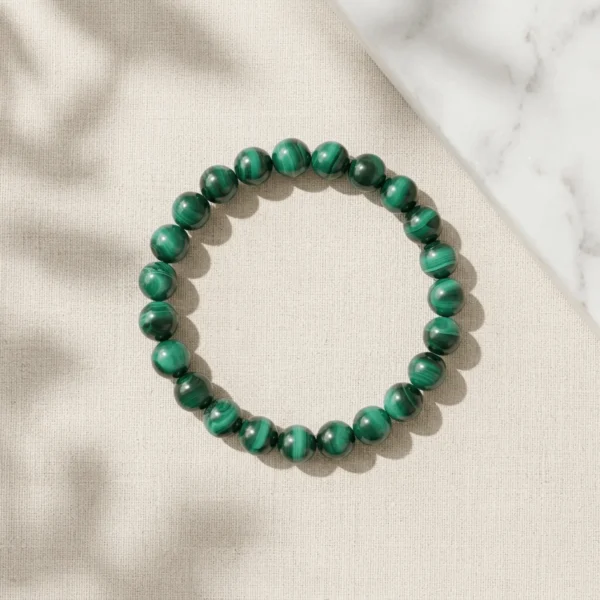 Malachite crystal bracelet 8mm with polished round beads on neutral background