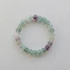 Top view of 8mm multicolored fluorite crystal bracelet showing translucent green and purple bead clarity