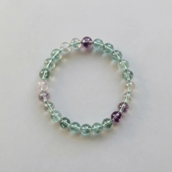 Top view of 8mm multicolored fluorite crystal bracelet showing translucent green and purple bead clarity