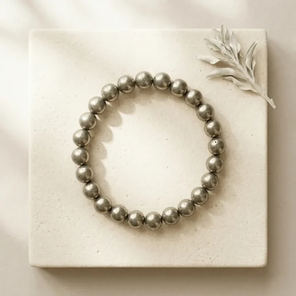 8mm Pyrite crystal bracelet with metallic gold beads on plain background