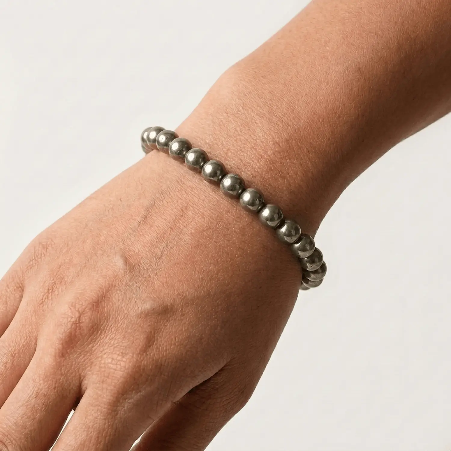 Close up of pyrite crystal bracelet on wrist showing bead size and metallic finish