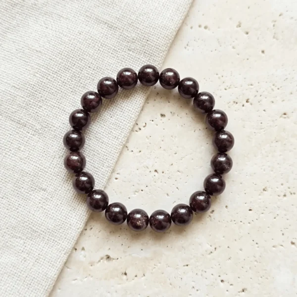 8mm Red garnet crystal bracelet with round polished deep red beads on neutral background