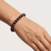 Close up of 8mm red garnet crystal bracelet on wrist showing bead size and shine
