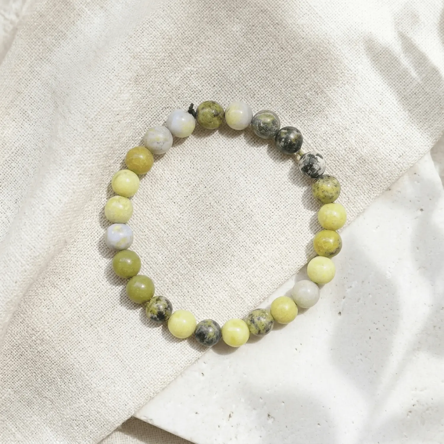 Serpentine crystal bracelet 8mm with polished round beads in mixed green and yellow tones showing natural patterns