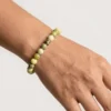Close up of Serpentine crystal bracelet on wrist showing smooth 8mm beads with natural green variations