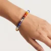 Close-up of seven chakra crystal bracelet on wrist showing bead colors and details