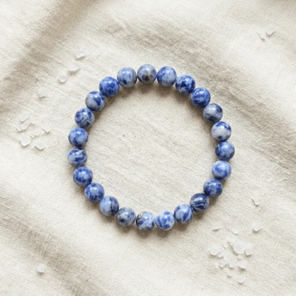 Sodalite crystal bracelet 8mm with round polished blue beads featuring natural white patterns on neutral background