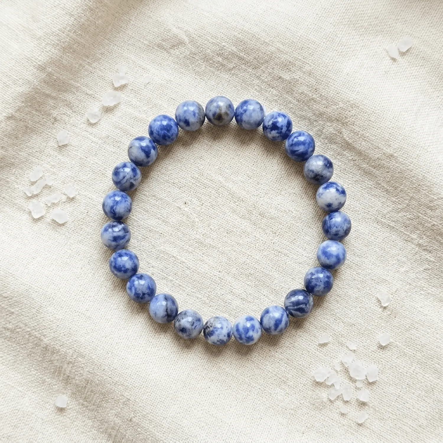 Sodalite crystal bracelet 8mm with round polished blue beads featuring natural white patterns on neutral background