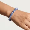 Close up of Sodalite crystal bracelet on wrist showing polished 8mm blue beads with natural white veining