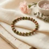Unakite crystal bracelet styled with soft fabric, flowers and crystals showcasing natural green and pink tones