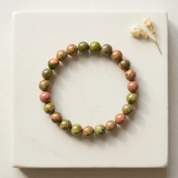 Unakite crystal bracelet 8mm with polished round beads showing natural green and pink mineral patterns on neutral background