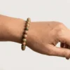 Close up of Unakite crystal bracelet on wrist showing smooth 8mm beads with green and pink natural variations