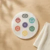 Round selenite plate with seven chakra symbols for crystal healing