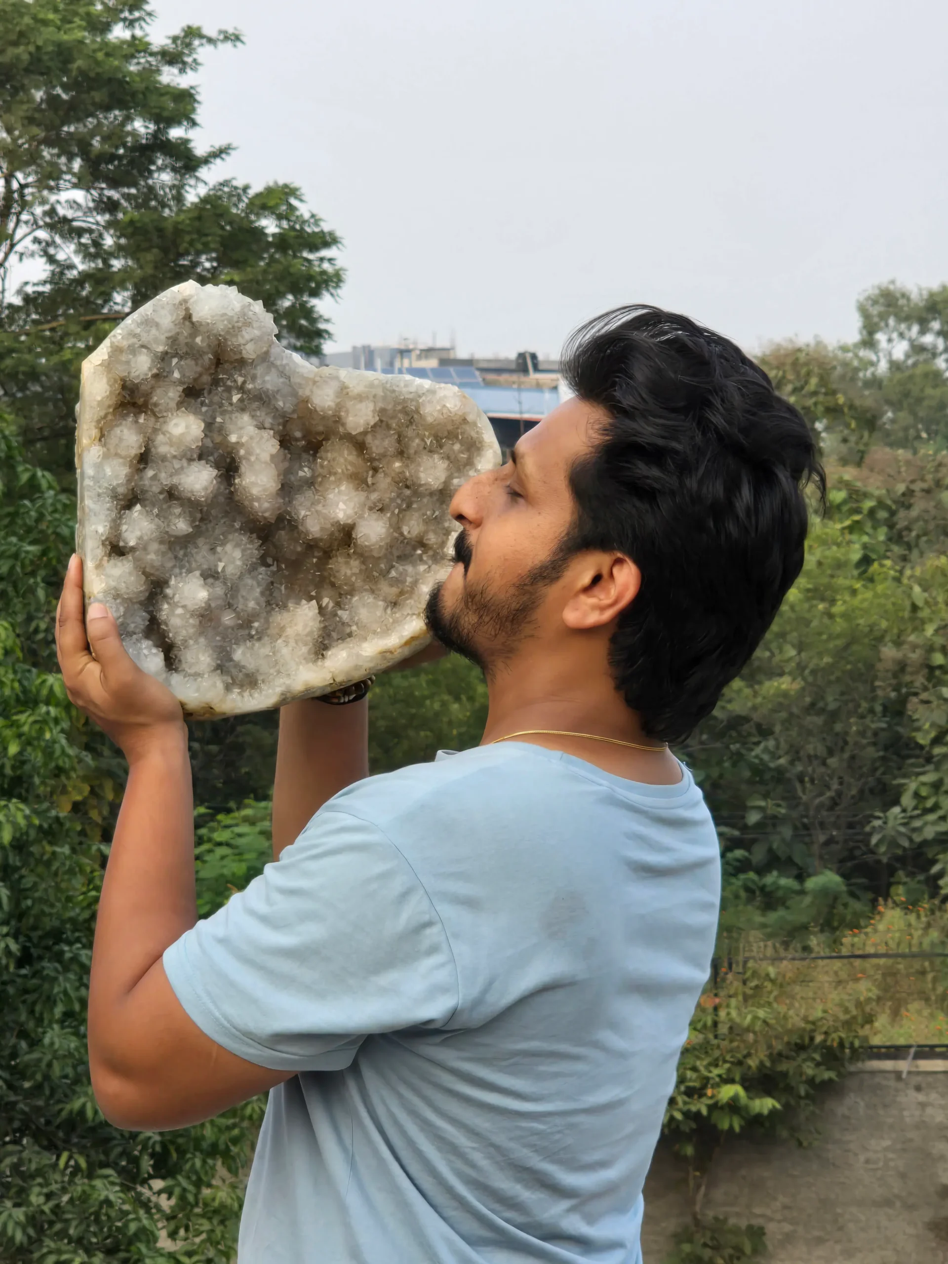 Kaivalya House of Crystals founder holding a large natural quartz crystal specimen